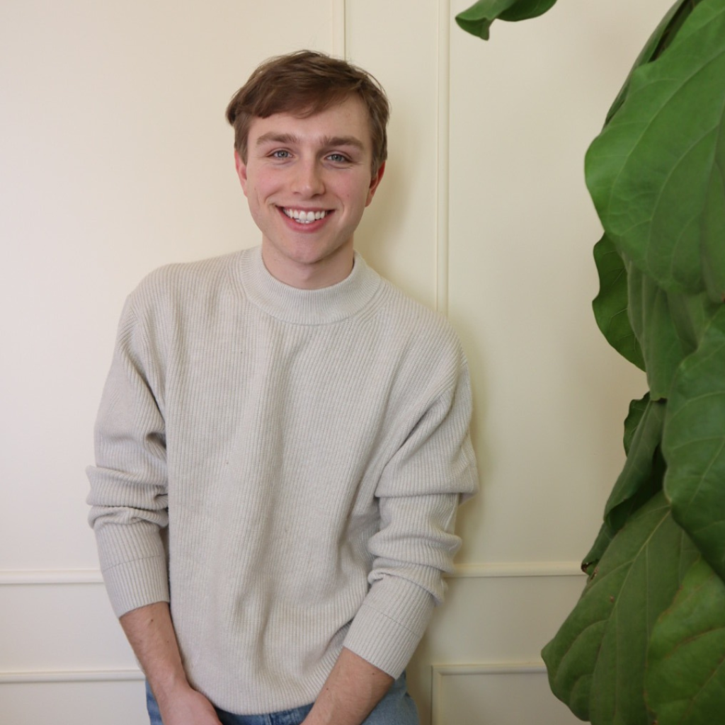 a man standing in front of a plant